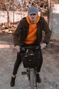 Woman in Brown Hoodie Riding on Bicycle