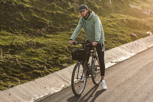 A Man with a Cap Riding a Bicycle