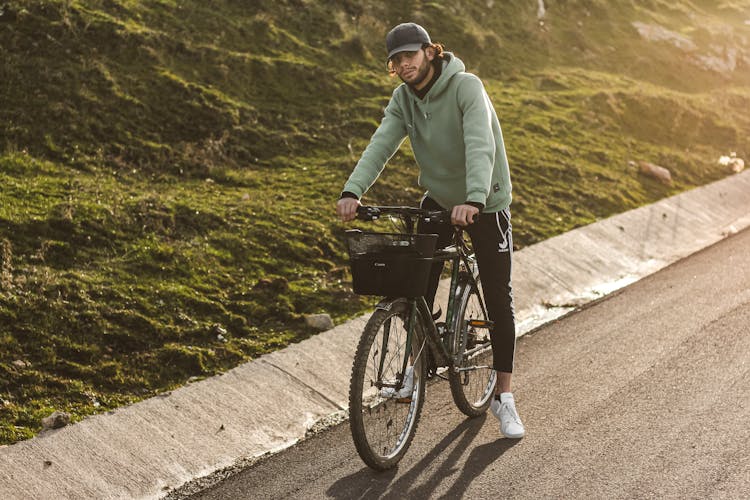 A Man With A Cap Riding A Bicycle