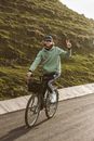 Man in Green Hoodie Riding Bicycle on Road