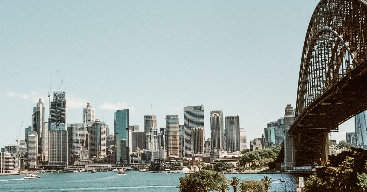 A captivating view of Sydney's skyline and iconic Harbour Bridge over the blue water.