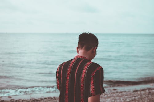 Man Wearing Black and Red Button-down Shirt Walking on the Beach