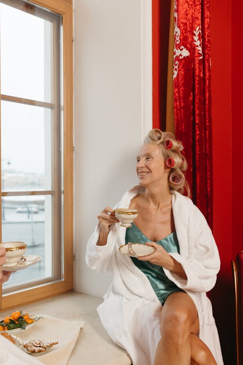 Free A Woman in a Bathrobe Holding a Cup and Saucer Stock Photo