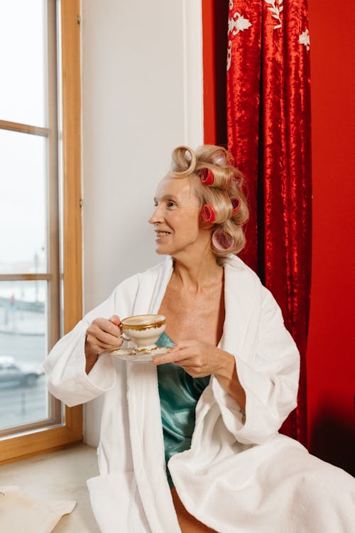 Free A Woman in a Bathrobe Holding a Cup and Saucer Stock Photo