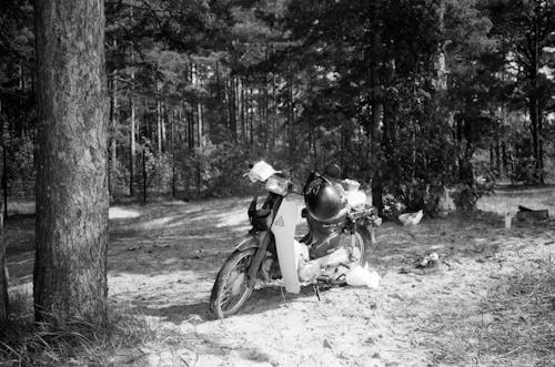 A Grayscale Photo of a Motorcycle in the Forest