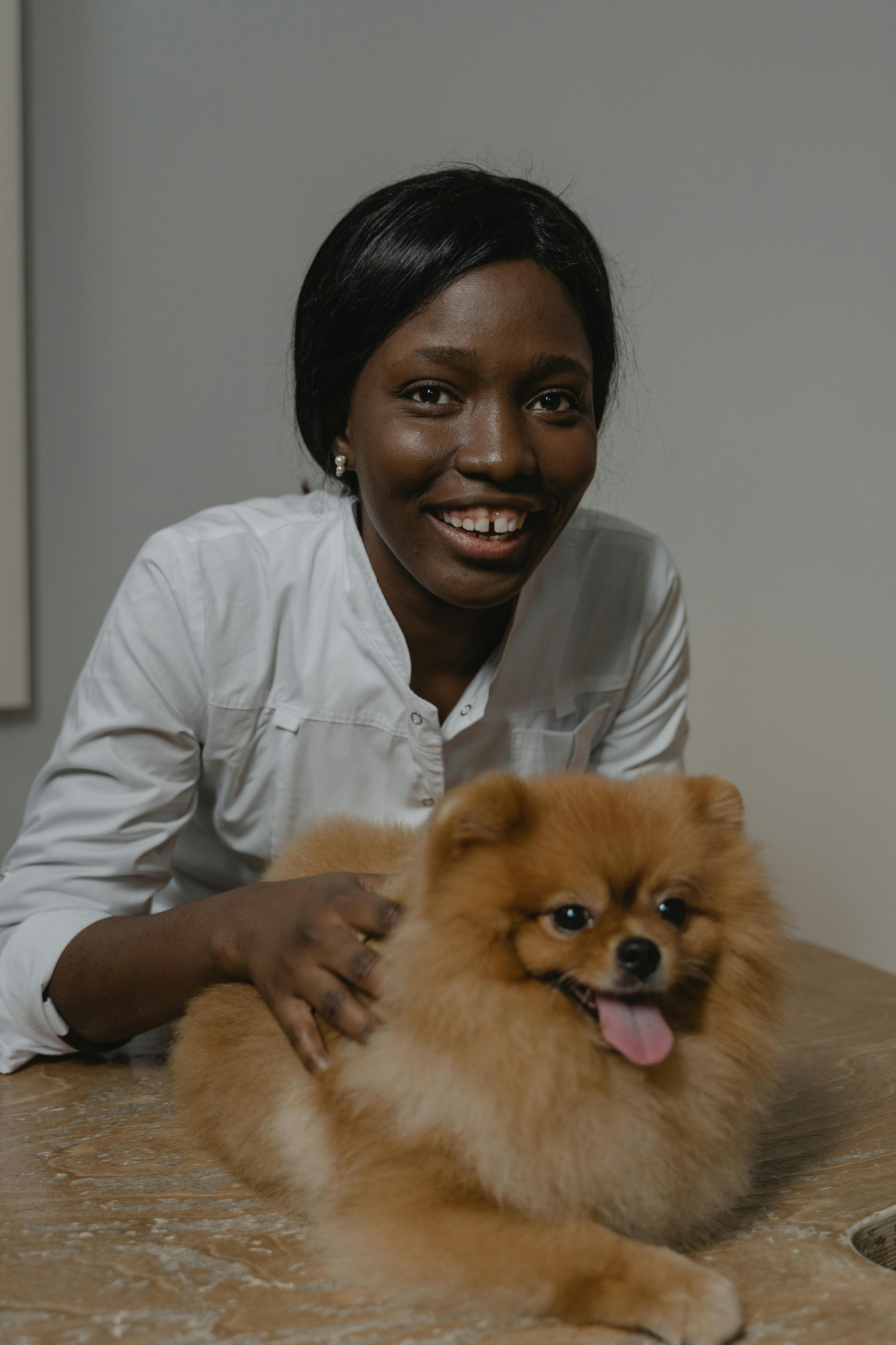 woman in white long sleeve shirt holding a dog