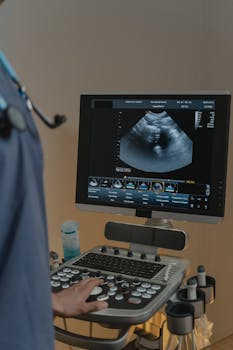 A healthcare professional using an ultrasound machine in a clinical setting.