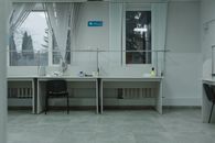 A clean and organized office space with desks, chairs, and large windows providing natural light.