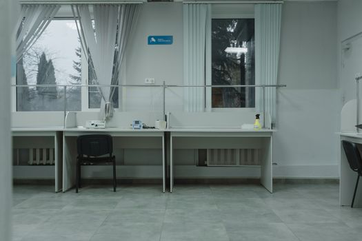 A clean and organized office space with desks, chairs, and large windows providing natural light.