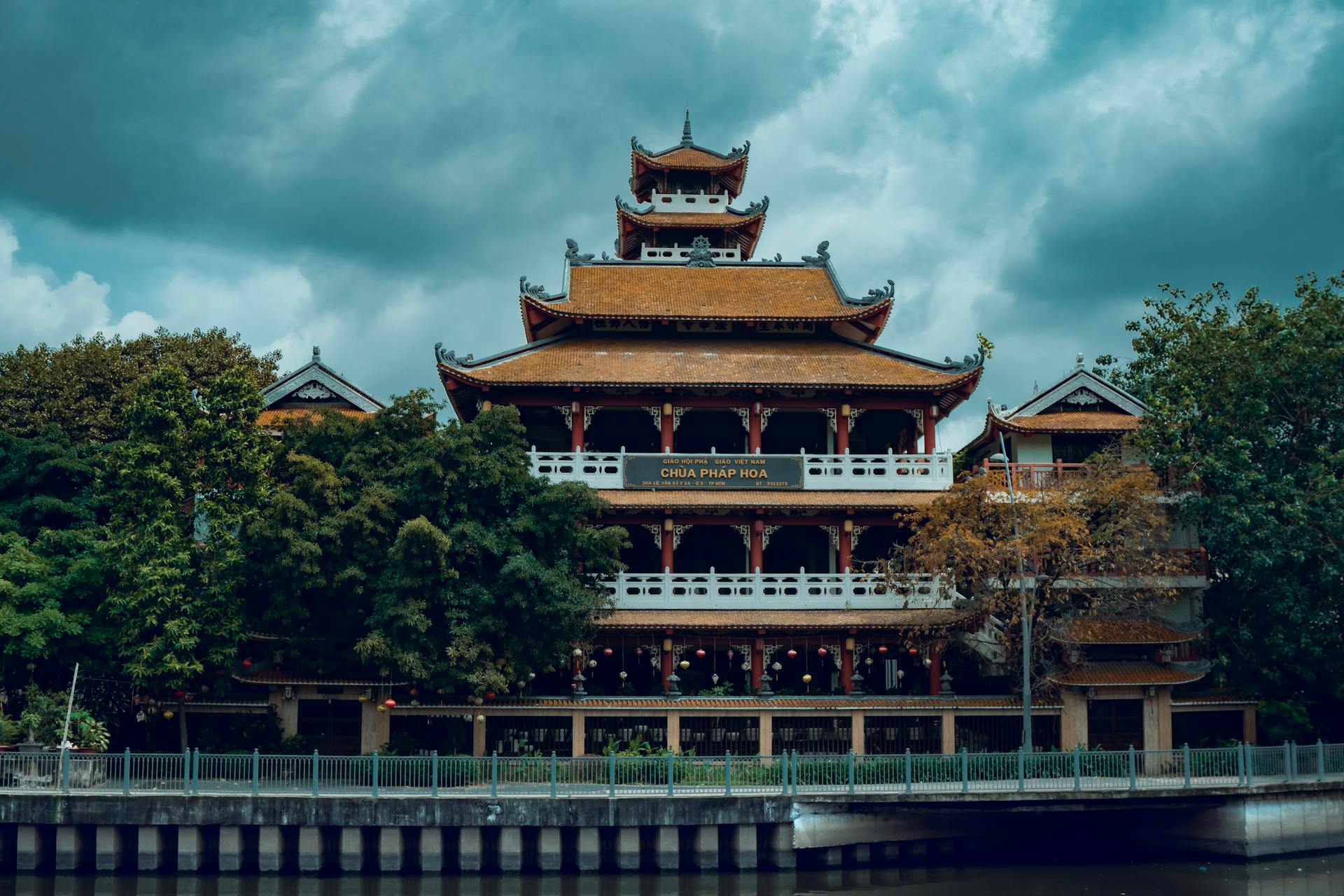 Chùa Pháp Hoa temple with traditional architecture under a cloudy sky, surrounded by lush vegetation.