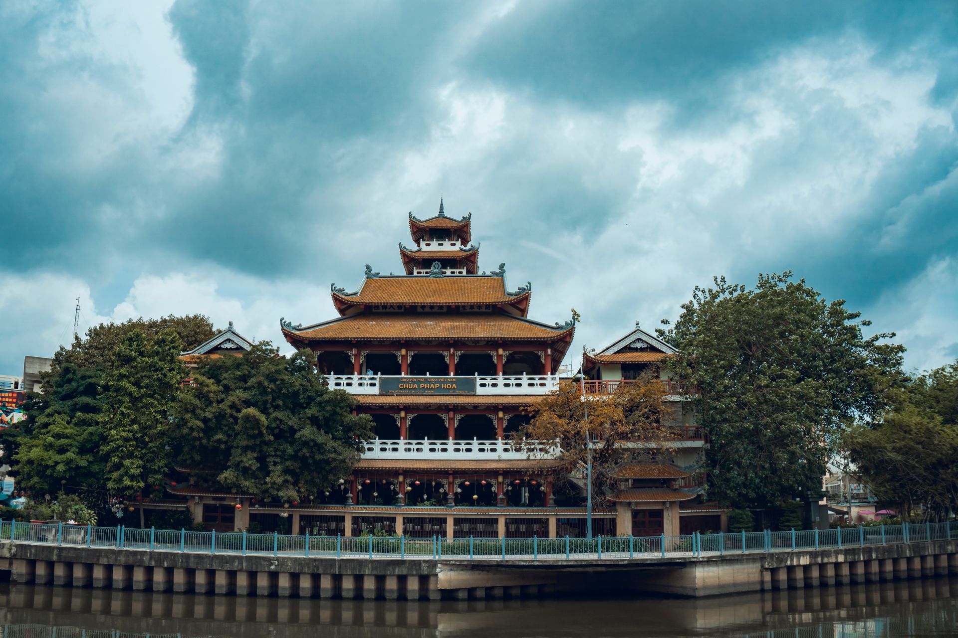 Chùa Pháp Hoa Temple captured on a cloudy day, showcasing traditional Vietnamese architecture by a serene lake.