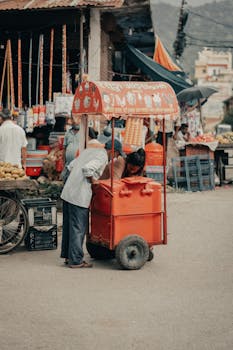 Ice cream cart at a bustling street market in Butwal, Nepal, showcasing local culture.