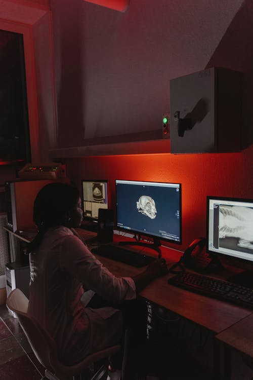 A Woman in White Long Sleeves Looking at the Image on the Monitor