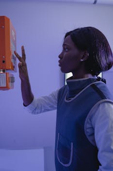 Side view of a focused African American female technician operating medical machinery indoors.