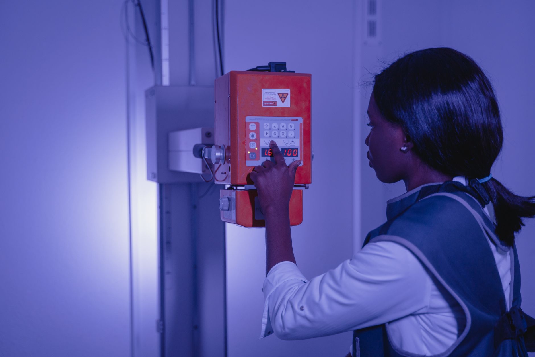Woman operating medical equipment in a high-tech lab setting.