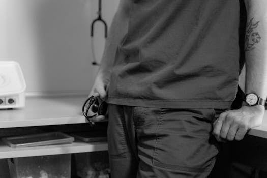 Black and white image of a tattooed medical professional in a clinic with a stethoscope