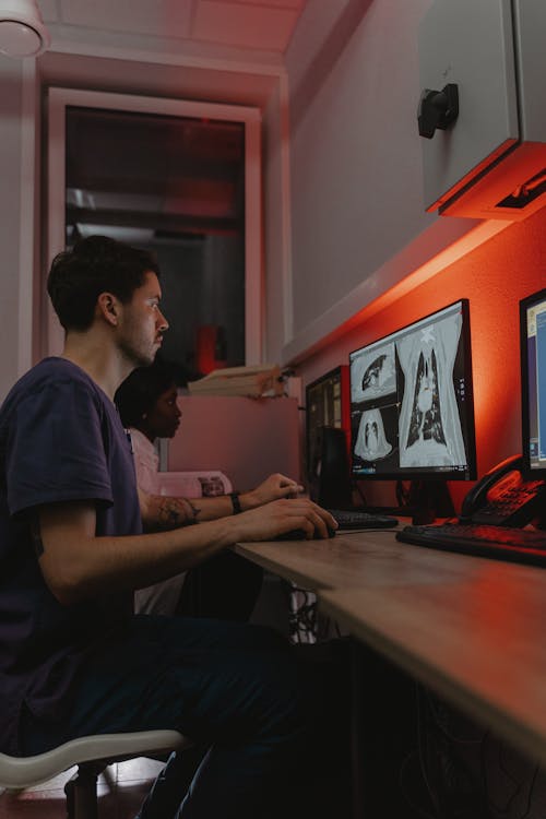 Free Medical People Looking at an Image on Computer Monitors Stock Photo
