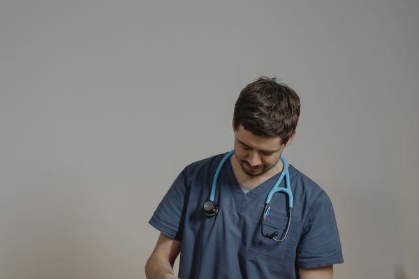 Caring veterinary doctor holding and supporting pet kitten