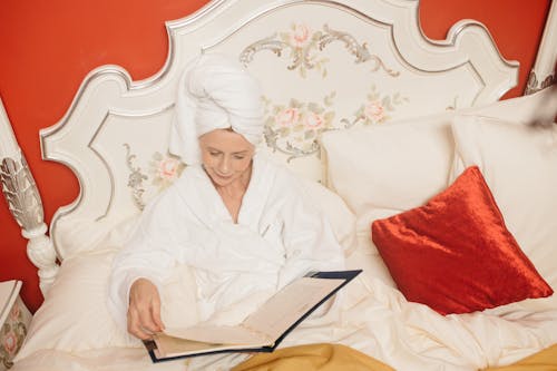 
A Woman in a Robe Looking at a Menu in Bed