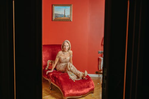 Woman in a Long Dress Sitting on a Red Chair