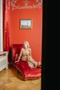 Woman Sitting on Red Chaise Lounge