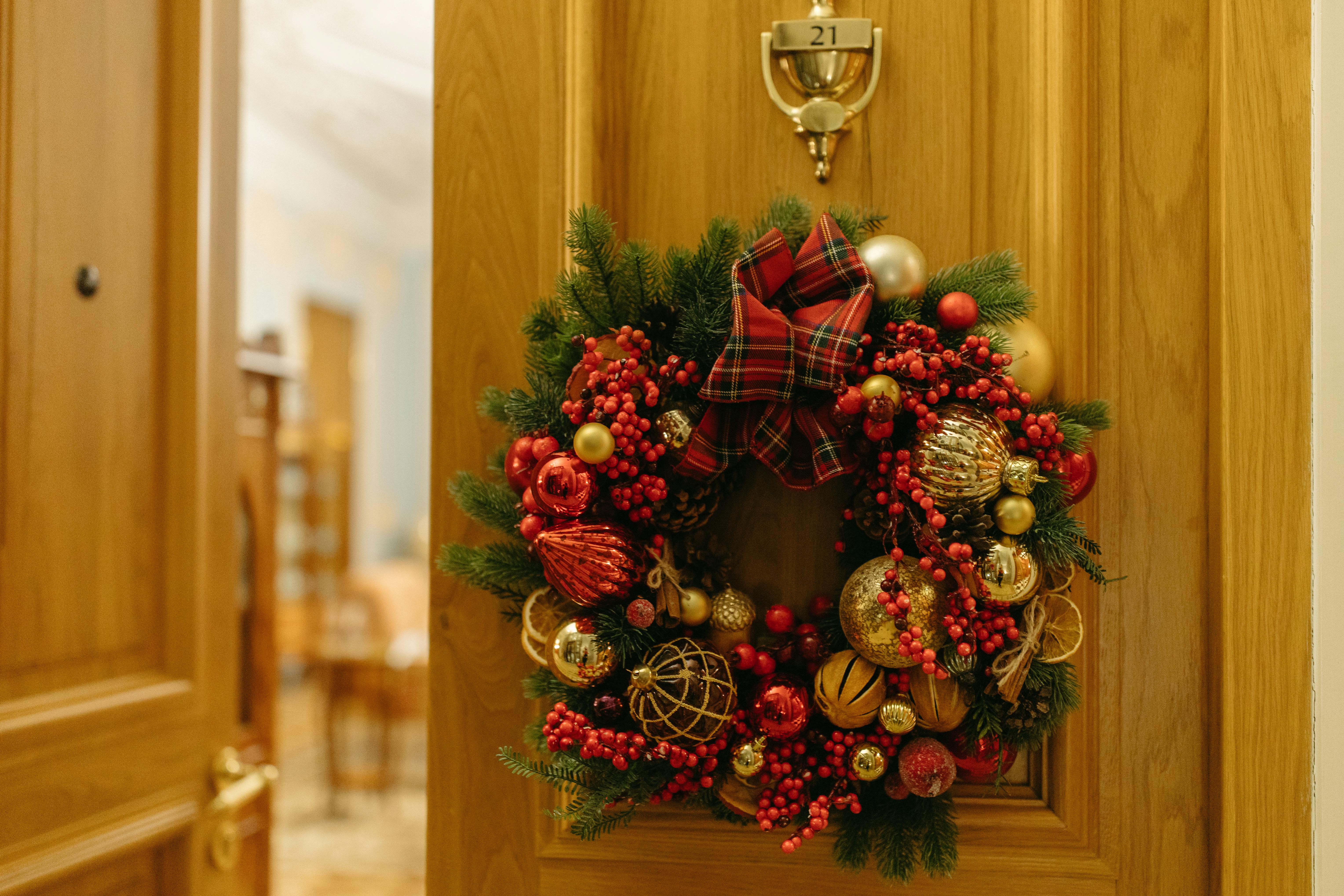 red and green wreath on brown wooden door