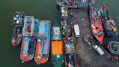 Free Aerial view of vibrant fishing boats docked at a bustling harbor in Vietnam. Stock Photo