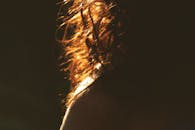 阳光下的卷发特写镜头，在光线中泛起温暖的金色光芒