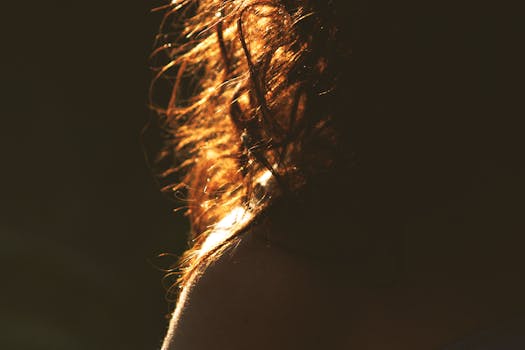 阳光下的卷发特写镜头，在光线中泛起温暖的金色光芒