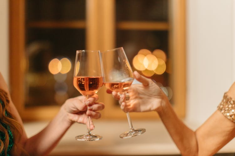 Two People Toasting Glasses Of Drinks