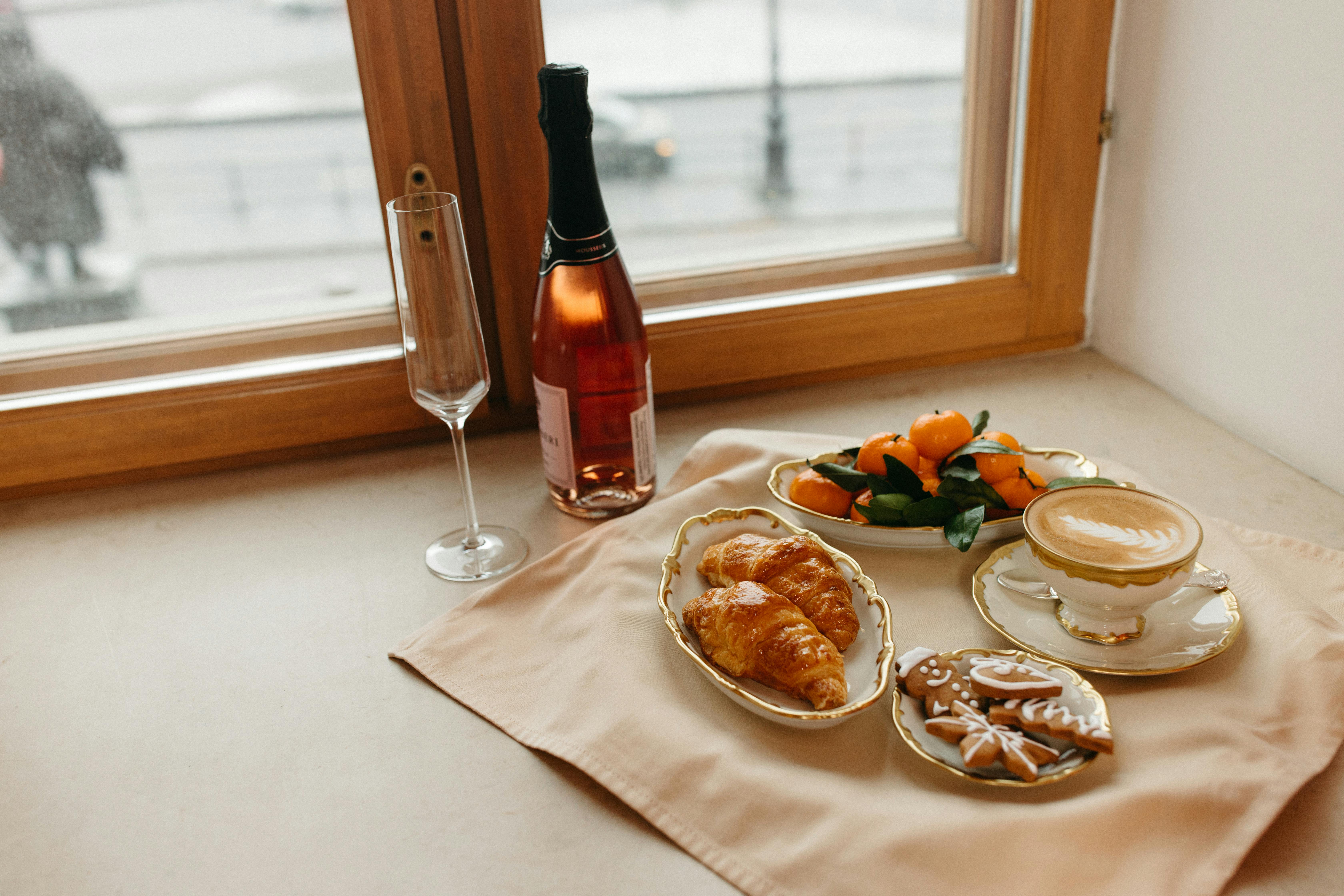 bread on white ceramic plate beside wine bottle and bread on table