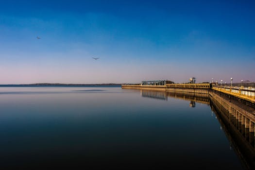 Serene landscape of KRS Dam in Mysuru, India, showcasing calm waters and clear skies.