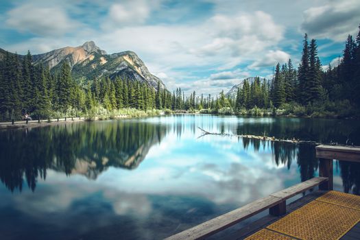 Stunning view of a calm mountain lake with reflections in Alberta, Canada.