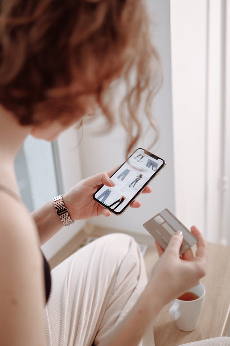 Woman Holding Cellphone And A Credit Card