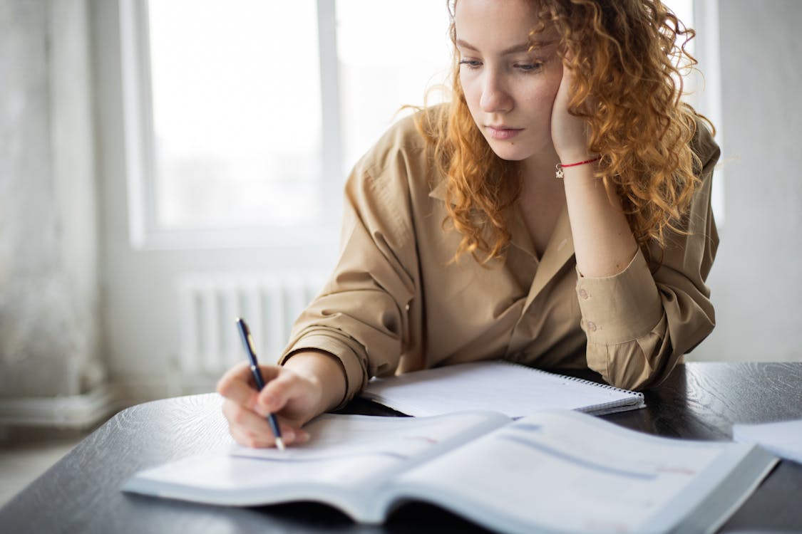 Free Crop clever woman writing in book Stock Photo