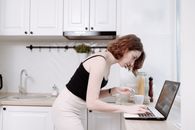 Woman in Black Tank Top and White Pants Holding Silver Laptop Computer