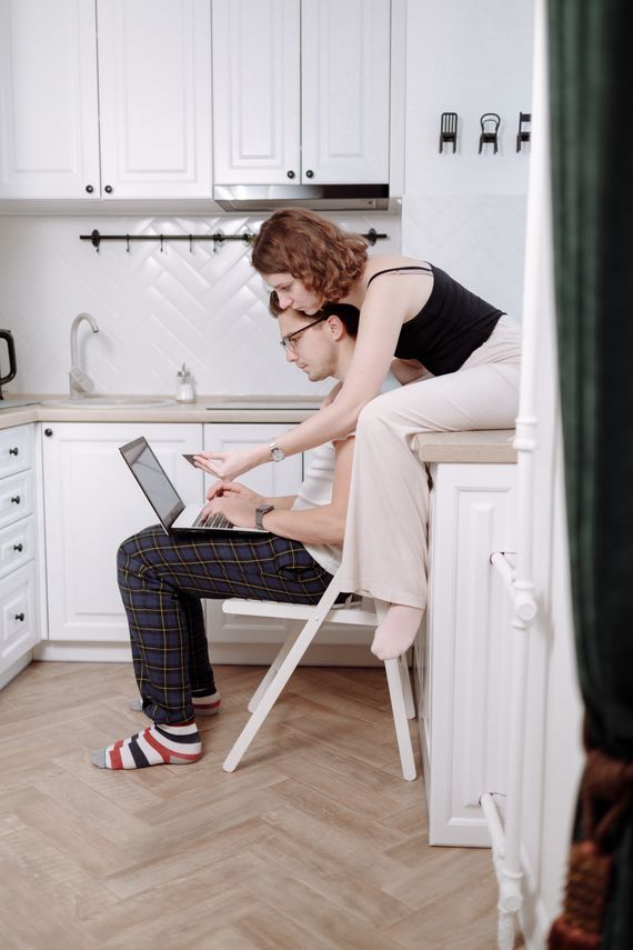 Couple using a laptop together in a modern kitchen