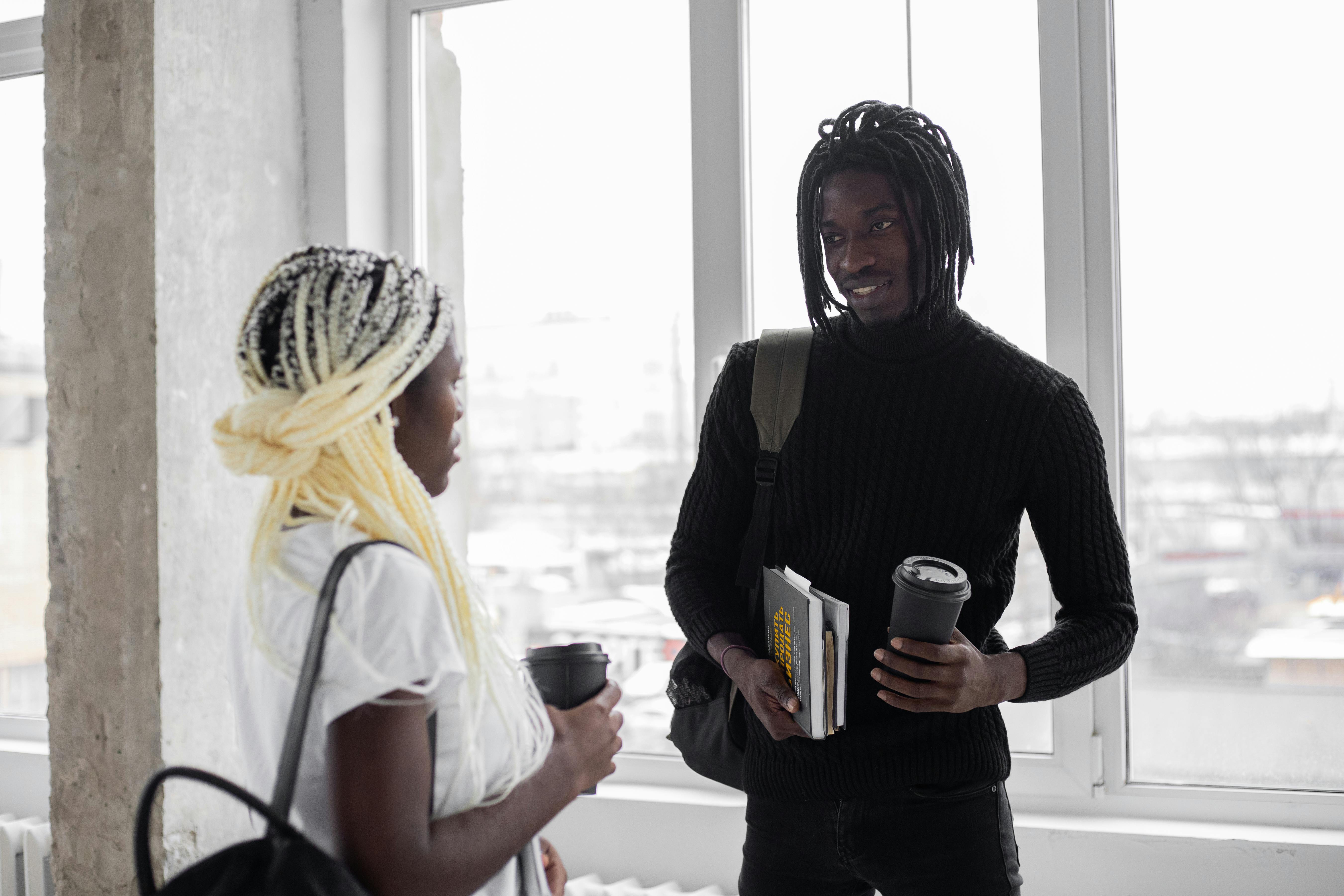 black students with takeaway coffee in room