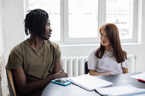 Black man and Asian woman studying together at table