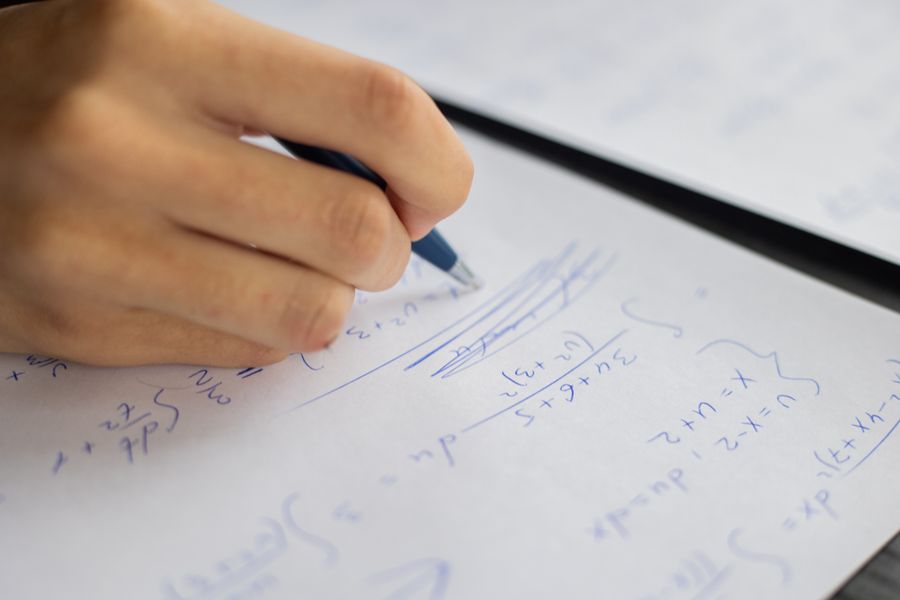 Student solving equations on paper during a lesson