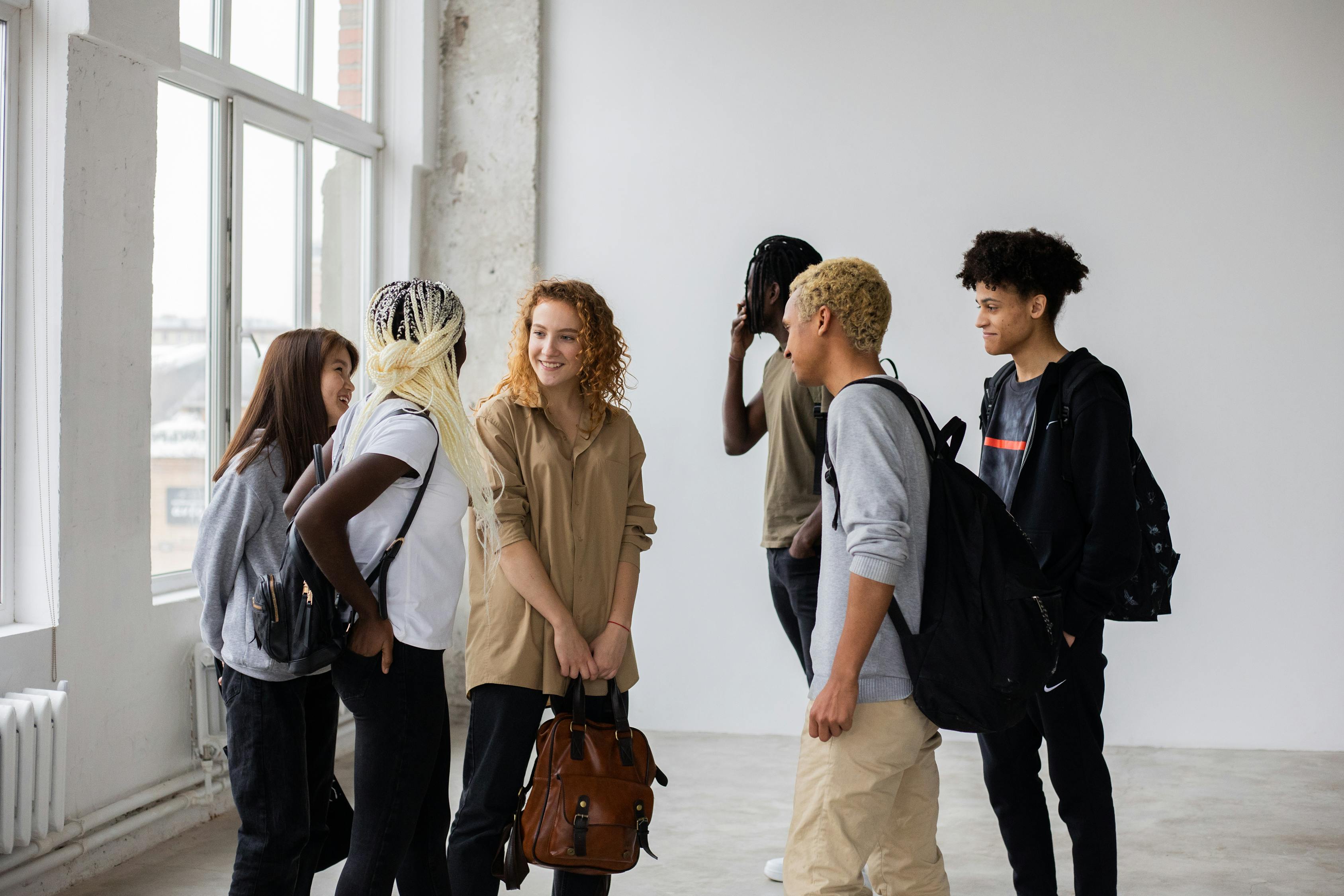 Diverse classmates talking to each other after studies · Free Stock Photo