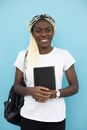 Cheerful black woman with notebook and backpack
