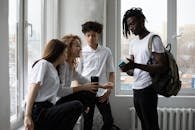 Young diverse students chatting near window