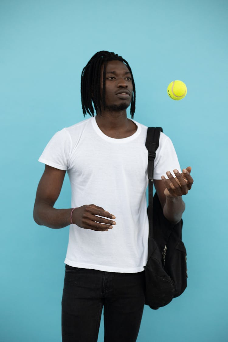 Black Man Juggling With Tennis Ball In Studio