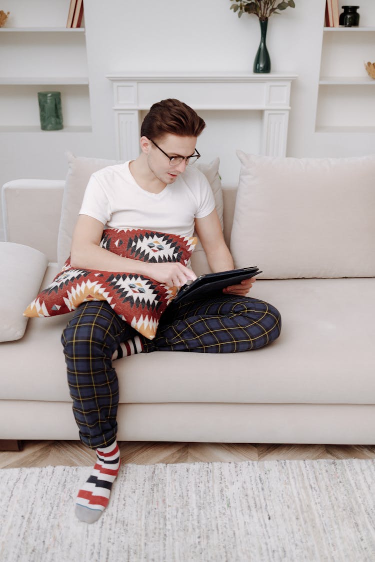 Man Sitting On A Couch Using A Tablet