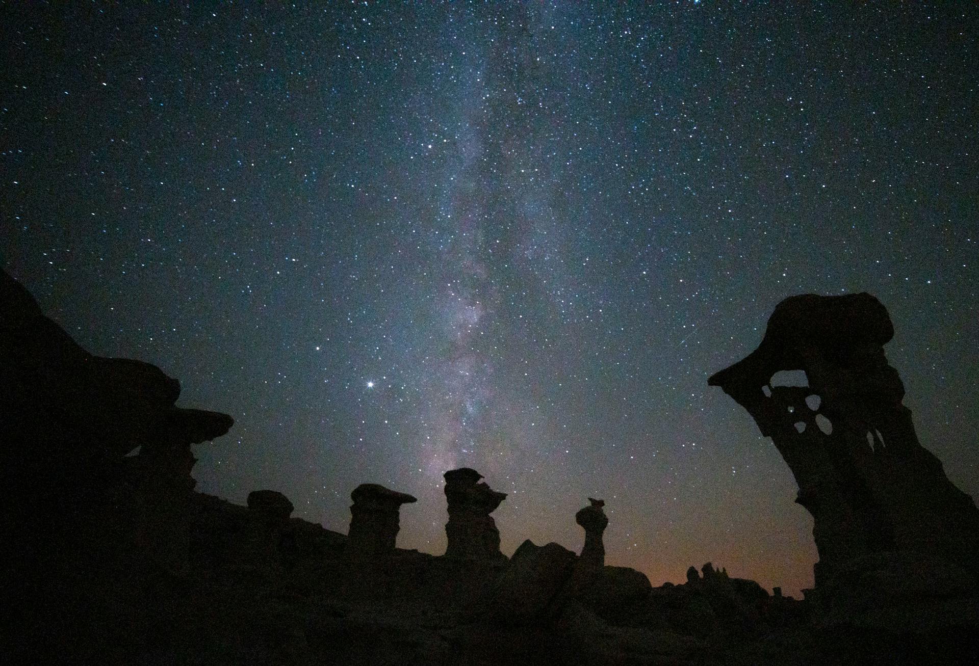 Astounding view of the Milky Way illuminating the hoodoo formations in New Mexico at night.