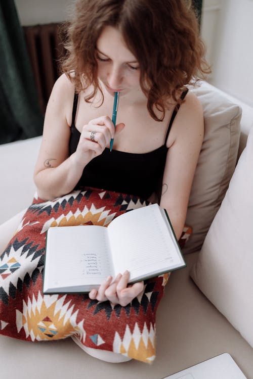 Free Woman Holding a Pen and a Notebook Stock Photo