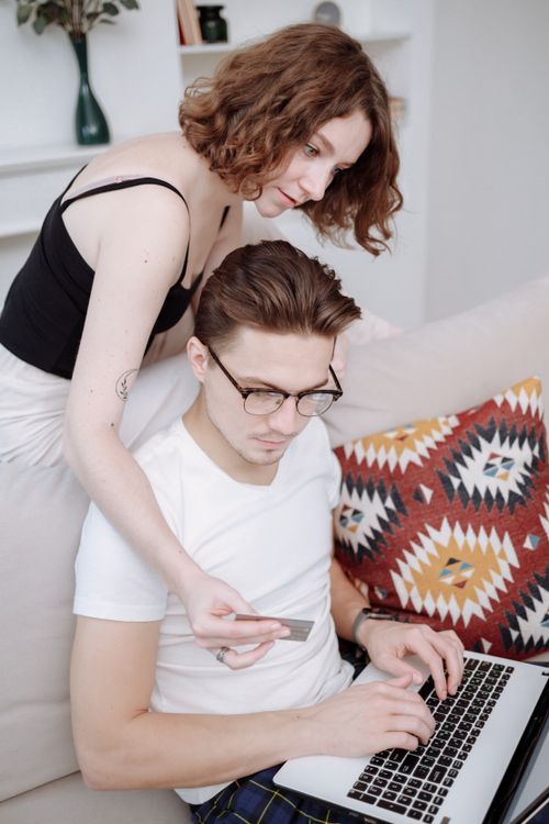 Free Young couple engaged in online shopping at home using a laptop and credit card. Stock Photo