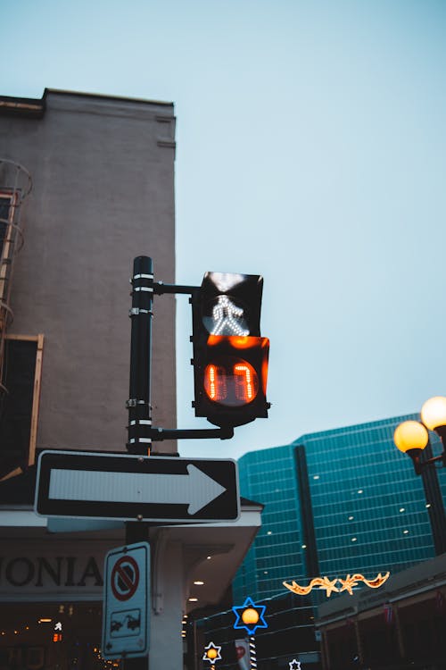 Traffic light above arrow sign on city street