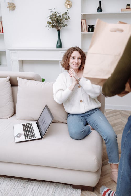 Free 
A Woman Wearing a Denim Pants Sitting on a Couch Stock Photo